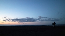 O regresso do bodyboarder num anoitecer . 