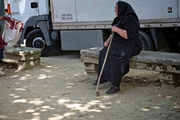 Mulher sentada com cajado 